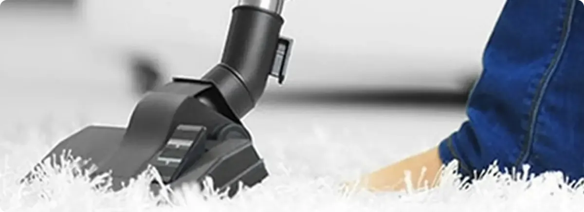 Close-up of a professional vacuuming a white carpet in Dayton.